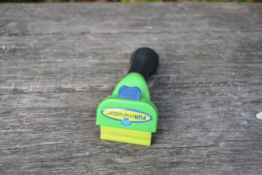 Pflegewerkzeug zur Entfernung loser Fellhaare und Unterwolle.